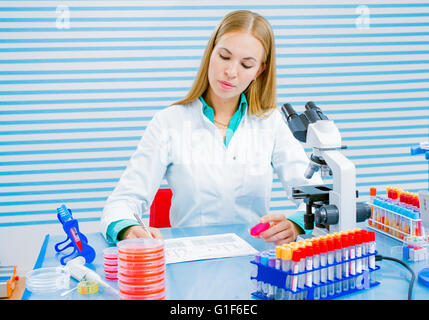 Parution du modèle. Assistant de laboratoire holding sample et prendre des notes dans le laboratoire. Banque D'Images