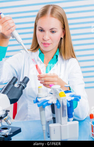 Parution du modèle. Assistant de laboratoire à la pipette pour remplir le tube micro. Banque D'Images