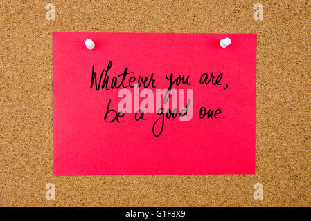 Papier rouge remarque avec texte manuscrit de celui que vous êtes, être un bon un épinglé sur le panneau de liège avec punaises blanches Banque D'Images