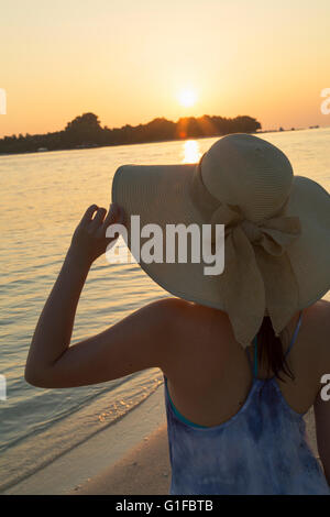 Femme sur la plage au coucher du soleil, l'île de Rasdhoo, Nord de Ari Atoll, Maldives Banque D'Images