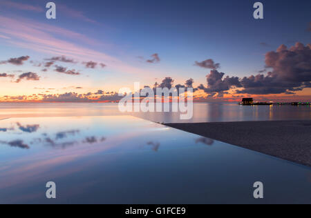 Piscine à débordement au Beach Garden and Spa Resort at sunset, South Male Atoll, Maldives, Atoll de Kaafu Banque D'Images