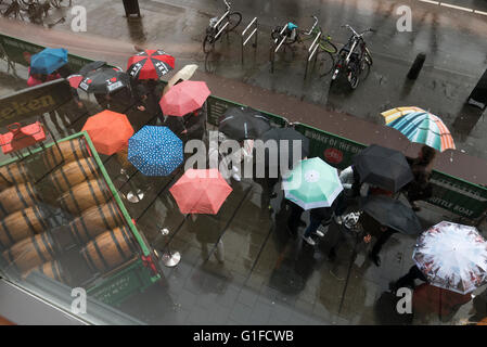 Les gens de la pluie avec des parapluies queue devant le bâtiment du Musée Heineken, Amsterdam, Hollande, Pays-Bas. Banque D'Images