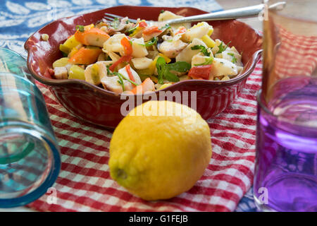 Salade de la mer avec des légumes et pommes de terre dans une soupière rouge Banque D'Images