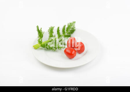 Brindille d'aneth et tomates cerises on white plate Banque D'Images