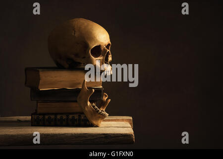 Crâne humain avec mâchoire sur de vieux livres Banque D'Images