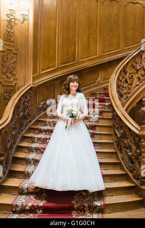 Heureux avec bride élégant bouquet de roses blanches sur le fond d'un escalier en bois ancien Banque D'Images