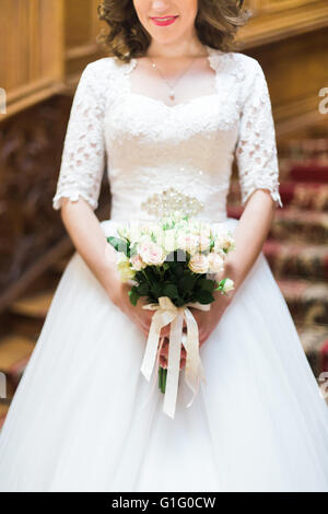 Heureux avec bride élégant bouquet de roses blanches sur le fond d'un escalier en bois ancien, close-up Banque D'Images