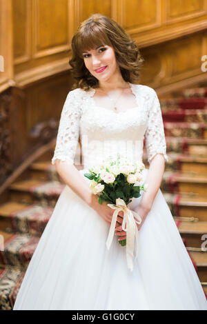 Heureux avec bride élégant bouquet de roses blanches sur le fond d'un escalier en bois ancien Banque D'Images