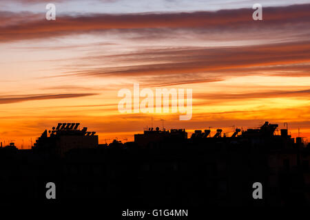 Photo conceptuelle de ville au centre-ville au lever du soleil/coucher du soleil avec une belle silhouette contre le ciel orange Banque D'Images