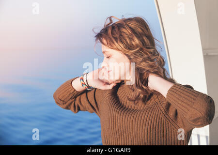 Belle happy blonde adolescente se tient sur le pont à pied de bateau de croisière, close-up portrait en extérieur Banque D'Images