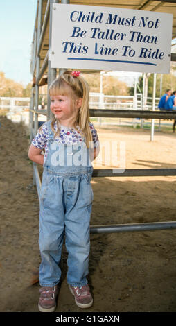 3 ans, fille, et contrôle de signer pour la hauteur de qualification ride poney.©Myrleen Pearson Banque D'Images