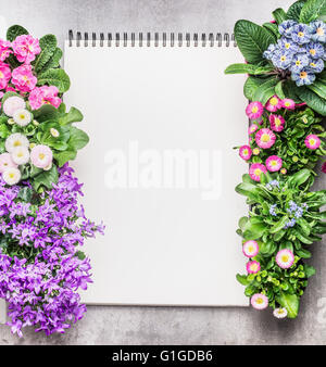 Ordinateur portable avec des fleurs de jardin en pots sur fond de pierre, vue du dessus. Image jardinage Banque D'Images