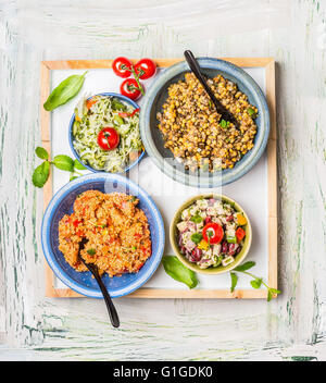 Les différentes salades plat sur la lumière de fond rustique. Accueil bar à salades. L'alimentation saine et de l'alimentation végétarienne concept Banque D'Images