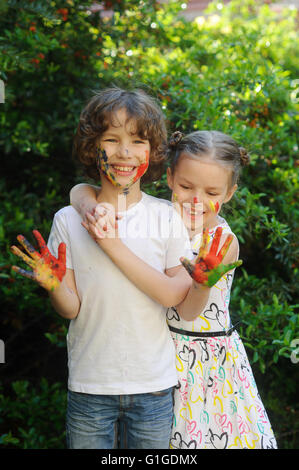 Embrasser les enfants, leurs visages et les mains dans la peinture Banque D'Images