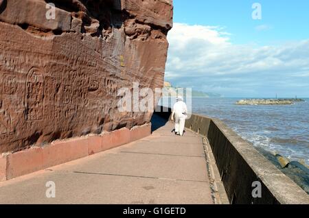 Dame âgée à pied par la digue en Devon Sidmouth UK Banque D'Images