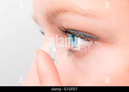 Femme de l'insertion d'une lentille de contact dans les yeux. Banque D'Images