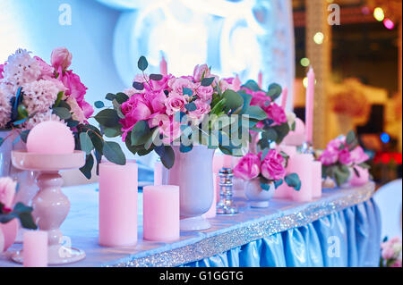 Set de table pour réception de mariage avec des bougies et bouquets de fleurs Banque D'Images