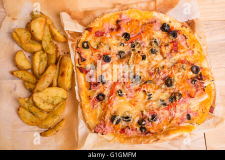 Des pizzas de frites sur une table en bois Banque D'Images