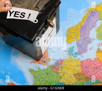 UK urne sur le dessus d'une carte de l'Europe. La main de l'homme mise en place d'un "oui" - en référence à l'organisation d'un référendum sur l'adhésion à l'UE Banque D'Images