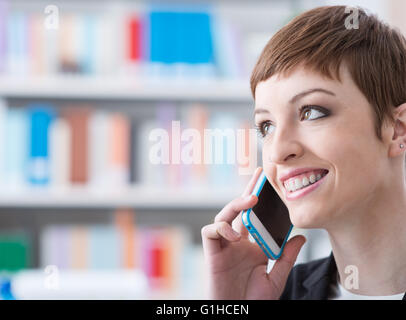 Smiling confident businesswoman au téléphone, elle appelle avec un téléphone intelligent Banque D'Images