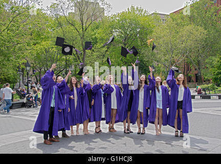 NYU asiatique diplômés jettent leurs casquettes en l'air pour une photo de groupe dans l'obtention du diplôme du parc de Washington Square à New York City Banque D'Images