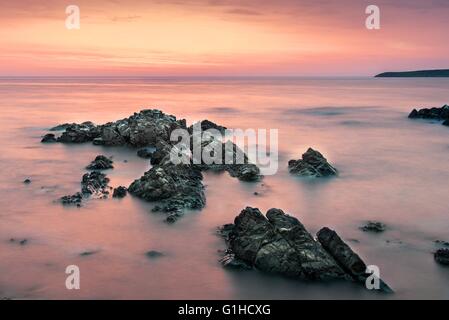 Colorful sunrise sur la mer vue de la plage rochers Banque D'Images