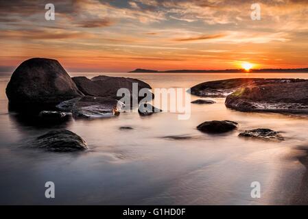 Colorful sunrise sur la mer vue de la plage rochers Banque D'Images