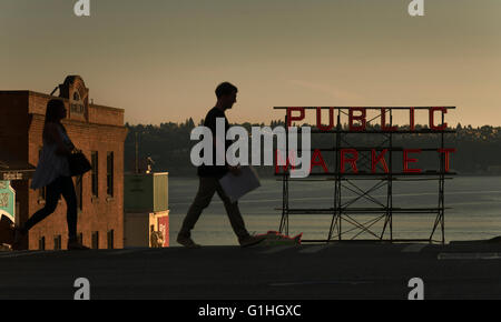 Une femme et l'homme marche en avant d'un signe pour le marché de Pike Place à Seattle, Washington, USA (Adrien Veczan) Banque D'Images