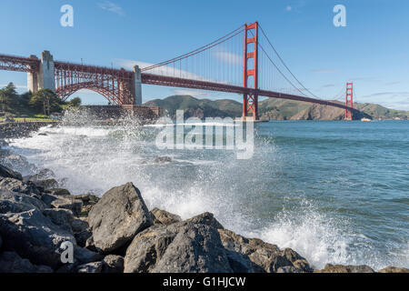 Vagues se brisant sur le rivage de la baie de San Francisco, avec le Golden Gate Bridge en arrière-plan. Californie, USA. Banque D'Images