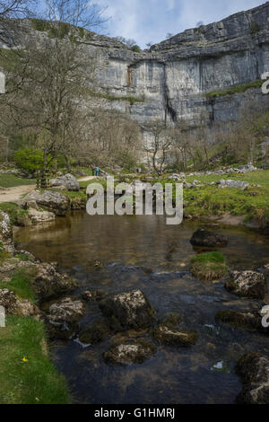 La gloire de Malham Cove, montrant le ruisseau qui s'écoule à partir de la base de la roche calcaire. Banque D'Images