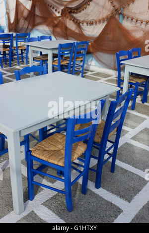 Chaises bleu, cyan vide du the tables sur blanchir à damiers marbre & filets de pêche decoration background.Myrina Lemnos,. Banque D'Images