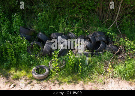 Une pile de pneus à côté d'une voie ferme dans le Shropshire, England, UK. Banque D'Images