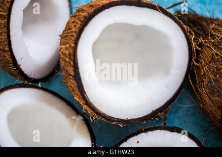 Les moitiés de noix de coco sur fond vibrant bleu Banque D'Images