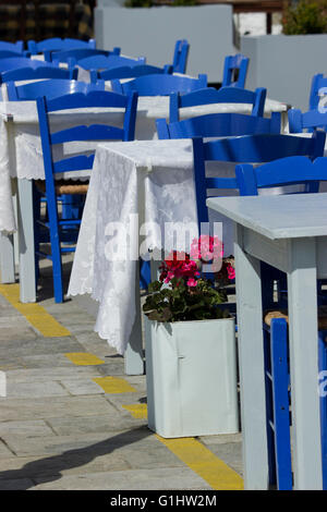 Pélargonium (famille des Géraniacées) plante décorant les rangées de tables vides du the blue sur la promenade de Myrina, Limnos Banque D'Images