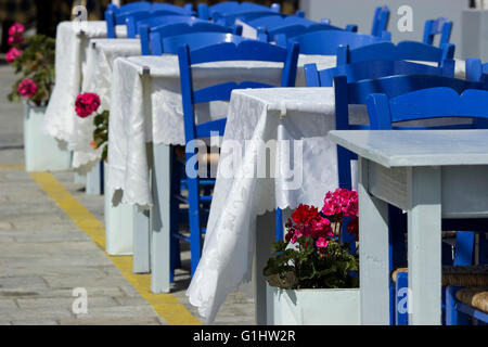 Pélargonium (famille des Géraniacées) fleurs décorant les rangées de tables vides du the blue sur la promenade de Myrina, Limnos Banque D'Images
