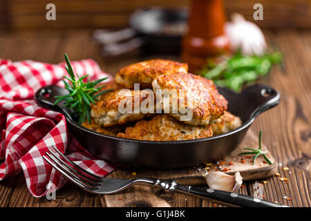Escalopes de viande dans la poêle sur la table rustique en bois Banque D'Images