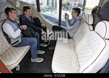 Kiev, Ukraine. 16 mai, 2016. La jeunesse se trouve à l'intérieur d'un premier prototype de voiture électrique ukrainienne 'Synchronous', au cours de présentation il à Kiev, Ukraine, le 16 mai, 2016. 'Synchronous" développé par entreprise ukrainienne Electric International Marathon est une voiture électrique avec moteur électrique innovant, panneaux solaires sur le toit, fenêtres panoramiques et l'extérieur qui me rappelle d'un chariot médiéval. La voiture en substance à l'utilisant comme une voiture de tourisme et de transport en taxi, et en mesure de surmonter la distance entre 130 et 160 kilomètres. © Vasyl Shevchenko/Pacific Press/Alamy Live News Banque D'Images