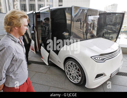 Kiev, Ukraine. 16 mai, 2016. Un homme d'oeil sur un prototype de voiture électrique premier Ukrainien 'Synchronous', au cours de présentation il à Kiev, Ukraine, le 16 mai, 2016. 'Synchronous" développé par entreprise ukrainienne Electric International Marathon est une voiture électrique avec moteur électrique innovant, panneaux solaires sur le toit, fenêtres panoramiques et l'extérieur qui me rappelle d'un chariot médiéval. La voiture en substance à l'utilisant comme une voiture de tourisme et de transport en taxi, et en mesure de surmonter la distance entre 130 et 160 kilomètres. © Vasyl Shevchenko/Pacific Press/Alamy Live News Banque D'Images