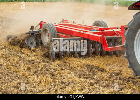 Le tracteur de cultiver les chaumes de blé champ, les résidus de récolte. Banque D'Images