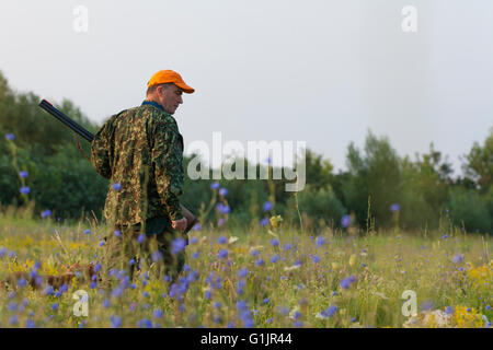 Chasseur mâle avec son chien à la chasse des oiseaux de caille. Banque D'Images