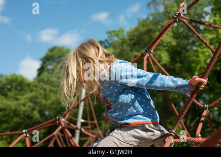 Très jolie jeune femme jouant sur la corde du web rouge en été Banque D'Images