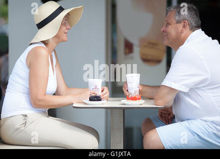 Vue latérale des deux personnes âgées en souriant outdoor cafe Banque D'Images