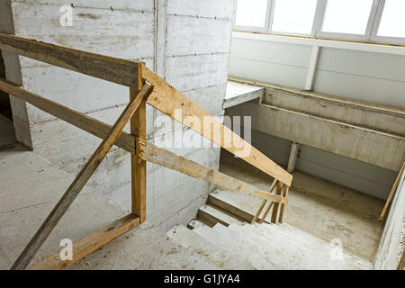 Nouvel escalier en béton avec des rampes en bois, en construction. Banque D'Images