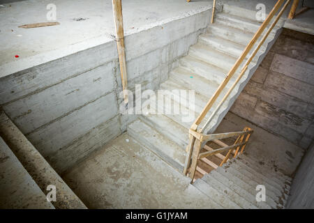 Nouvel escalier en béton avec des rampes en bois, en construction. Banque D'Images