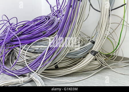 Un faisceau de câbles de communication sont suspendus au plafond dans la chambre. Banque D'Images