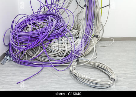 Un faisceau de câbles de communication sont suspendus au plafond dans la chambre. Banque D'Images