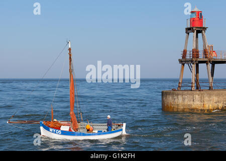 Un bateau de mettre les voiles pour la mer du nord de Whitby Harbour. Banque D'Images