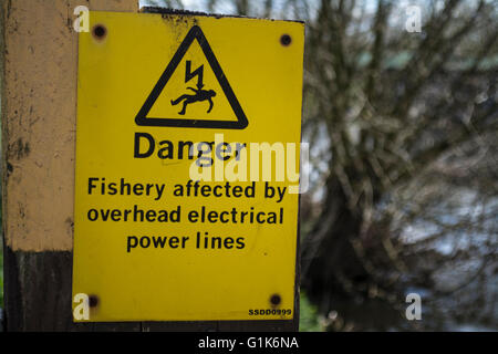 Panneau d'avertissement jaune de lignes électriques aériennes par la rivière Soar, Leicestershire Banque D'Images