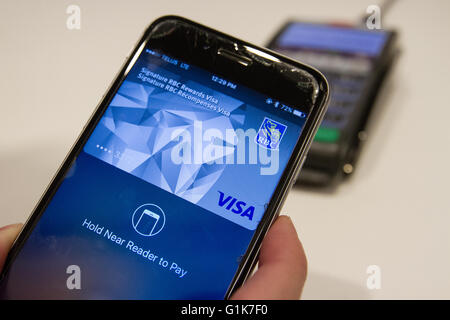 Un client utilise payer Apple app sur un iPhone à payer un article à aller + computer magasin à Kingston (Ont.), le 16 mai 2016. Banque D'Images