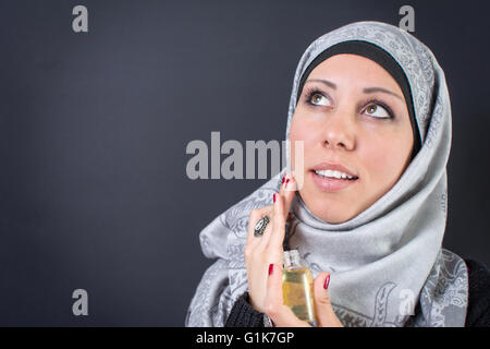 Belle femme musulmane dans hijab avec un parfum Banque D'Images